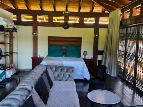 a living room with a couch and a bed at eKuthuleni - Wooden Cabin over the dam in Howick