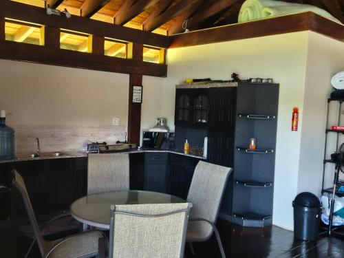 a kitchen with a table and chairs and a counter at eKuthuleni - Wooden Cabin over the dam in Howick