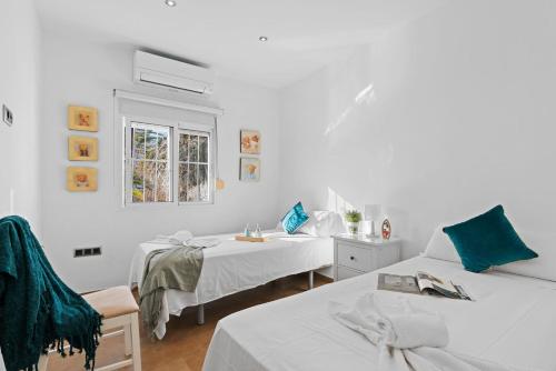 a white room with two beds and a window at Villa Baobab - Plusholidays in Ifach