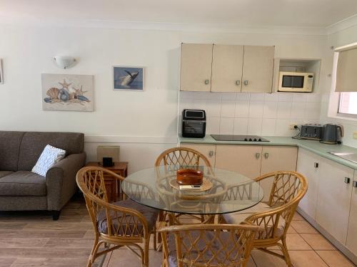 a kitchen with a glass table and chairs in a room at Beachfront at Silver Sands Hervey Bay in Hervey Bay