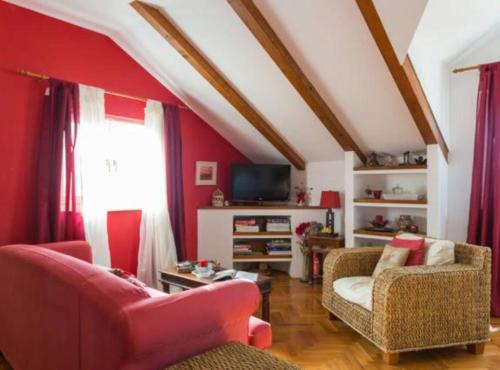 a living room with red walls and red furniture at Apartment Lukre Mala in Dubrovnik