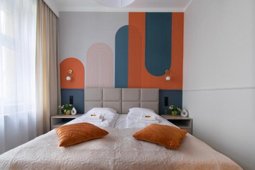 a bedroom with a large bed with two pillows at Central Apartments Warszawska Street in Krakow