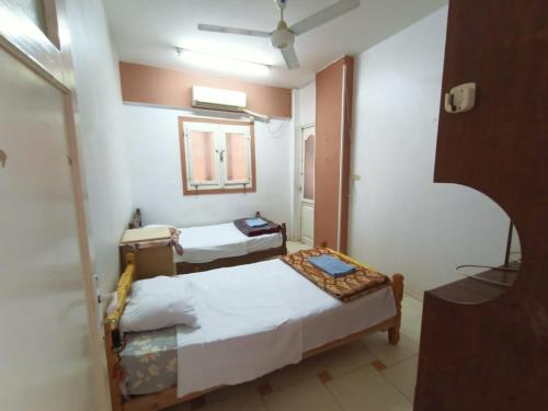 una camera con due letti e uno specchio di david hostel a Aswan