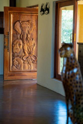 a toy dog standing in front of a wooden door at Parsons House in Hoedspruit
