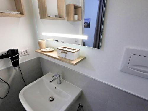 a white bathroom with a sink and a mirror at Relais Villa Borghese in Rome