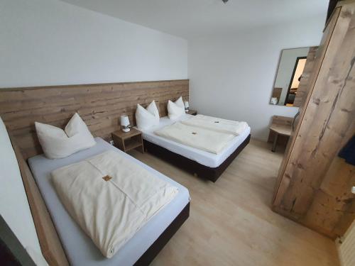 1 dormitorio con 2 camas y espejo en Fränkischer Hof --- Hotel in Pegnitz --- Schlabecks Fränkischer Hof, en Pegnitz