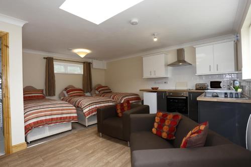 a living room with two beds and a kitchen at Castle Lodge in Crosskeys