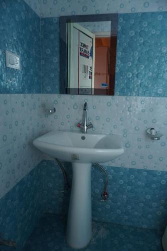 a bathroom with a white sink and a mirror at Manali Mountain Resort in Manāli