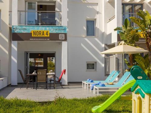 a patio with a slide and a table and chairs at Villa Nora in Protaras
