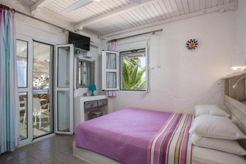 1 dormitorio con cama rosa y ventana en Hotel Irini, en Livadia