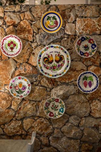 a bunch of plates on a stone wall at Hotel Irini in Livadia
