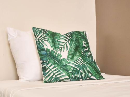 Stay Inn Plus في Mexico: وسادة خضراء وبيضاء على سرير