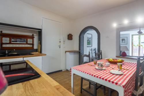 a kitchen and dining room with a table with a red and white table cloth at DolomiApartments - Appartamento Girasole in Predazzo