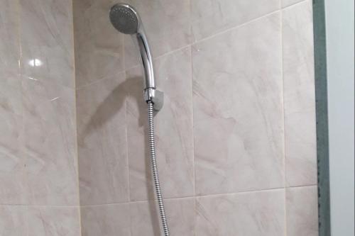 a shower with a shower head in a bathroom at OYO 93759 Yume Guest House in Midang