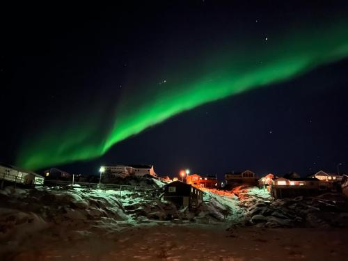 an image of the northern lights in the sky at Illu Rental - Whale View Vacation House in Ilulissat