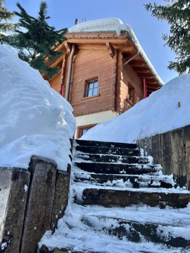 a log cabin with snow on the steps at Chalet Cirmolo in Livigno