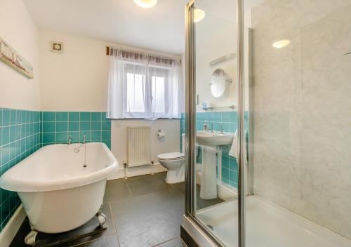 La salle de bains est pourvue d'une baignoire, de toilettes et d'un lavabo. dans l'établissement Oriel Cottage, à Bittadon