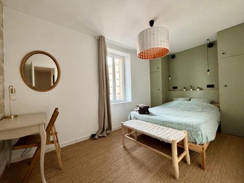 1 dormitorio con cama, mesa y espejo en Arles fait sa révolution en Arlés