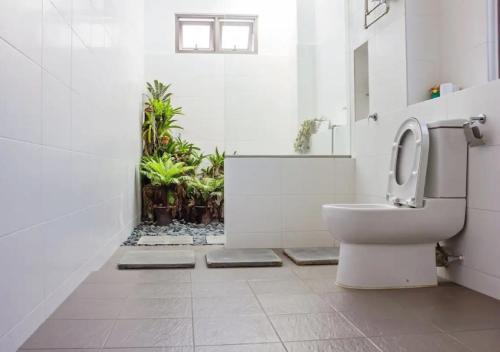 a bathroom with a toilet and plants in it at Three Storey Garden Home at Bukit Gambir 18ppl in Gelugor