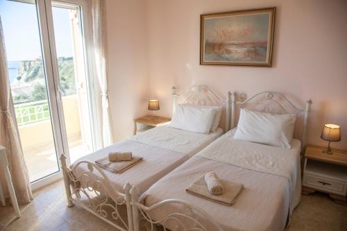 a bedroom with a white bed with towels on it at Grand View Retreat at "Avythos" Βeach in Kaligata