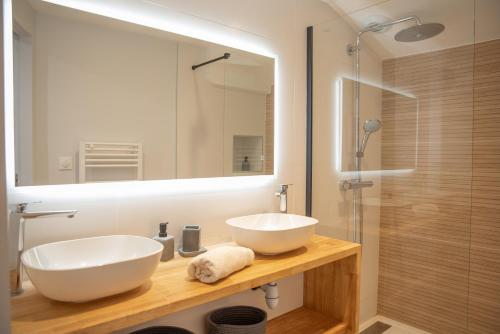 W łazience znajduje się biała umywalka i lustro. w obiekcie La maison rue Nadaud, au pied des remparts w Carcassonne
