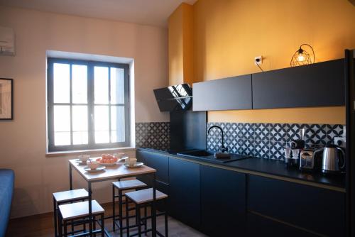 kuchnia ze stołem i krzesłami oraz oknem w obiekcie La maison rue Nadaud, au pied des remparts w Carcassonne