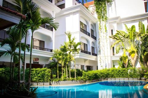 a hotel with a swimming pool in front of a building at ANGKOR TRAILS Residence in Siem Reap