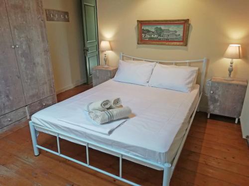 a white bed with two towels on top of it at Zoe's Yard family Summer House at Mon Repos in Anemómylos