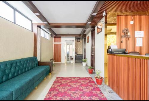 uma sala de estar com um sofá verde e um tapete vermelho em Hotel Vimal Ganga em Rishikesh