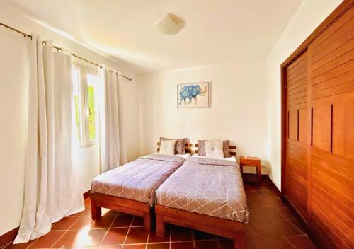 een slaapkamer met een bed en een houten deur bij Scenic Riverfront 2 Bedroom Villa in Port Chambly in Baie du Tombeau