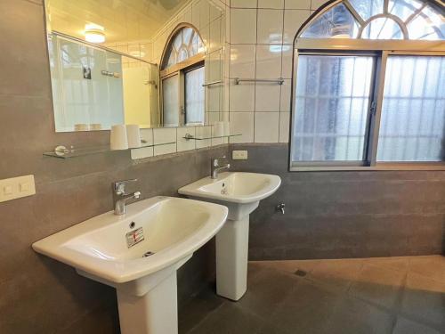 a bathroom with two sinks and a mirror at Gemlu in Lugu