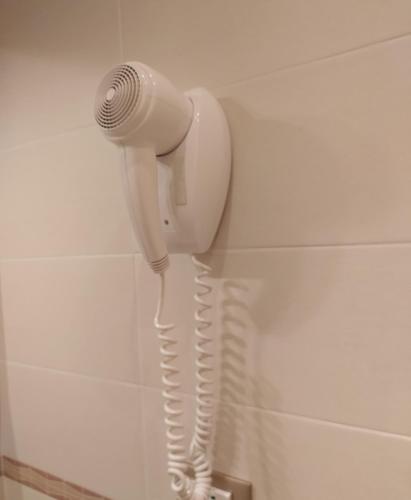 a blow dryer hanging on a wall in a bathroom at Casa Gordigiani - bilocali con parcheggio in Florence