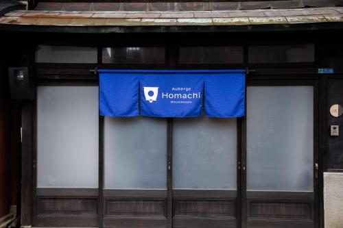 a blue sign on the front of a building at Auberge Homachi Mikuniminato in Sakai