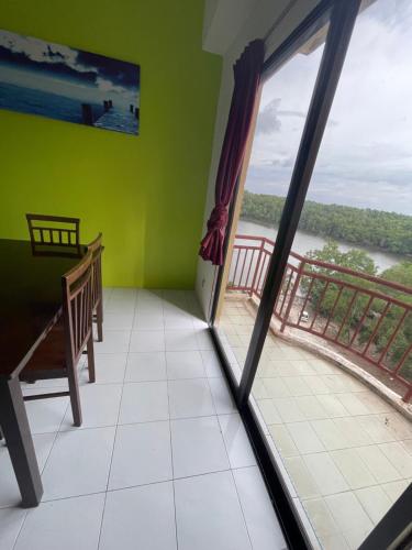 a room with a window and a balcony with a view at Dindings Pantai Desair Apartment By DPD in Lumut