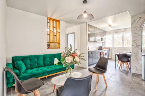 sala de estar con sofá verde y sillas en La Casa Will - Family flat for 8, en Hérouville-Saint-Clair