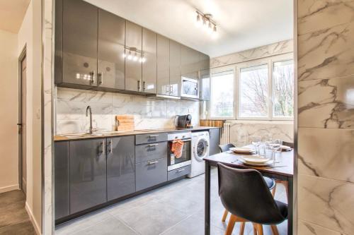 cocina con mesa y fregadero en La Casa Will - Family flat for 8, en Hérouville-Saint-Clair