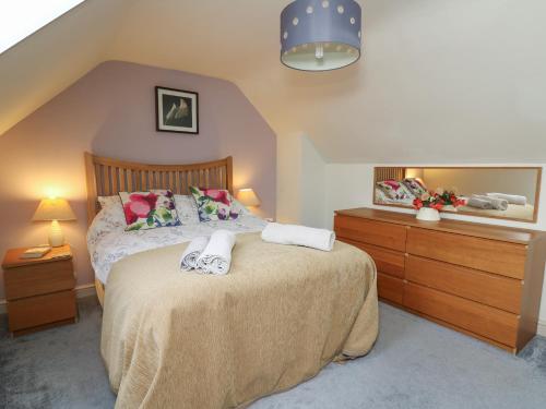 a bedroom with a bed with two towels on it at Penally in Llandysul