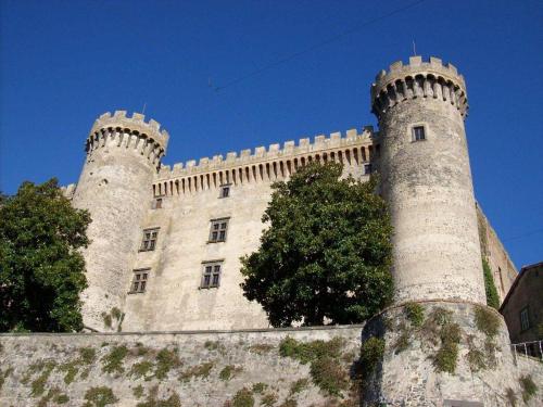 a castle with two towers on top of a wall at La Colombaia Nel Castello in Bracciano