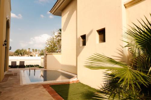 The Atlantis Hotel View, Palm Family Villa, With Private Beach and Pool, BBQ, Front F في دبي: منزل به مسبح بجانب مبنى