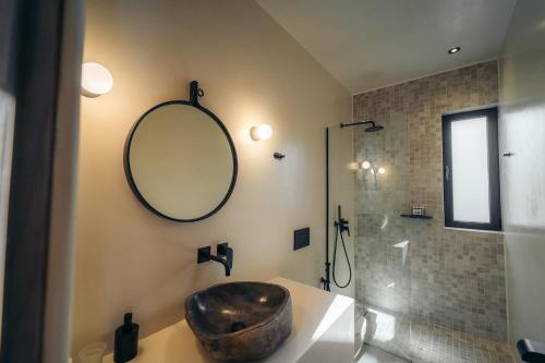 a bathroom with a sink and a mirror and a shower at Hide Out Villas in Mylopotas