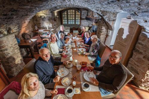 eine Gruppe von Menschen, die in einem Restaurant an einem Tisch sitzen in der Unterkunft Le Barry du Grand Chemin in Le Caylar