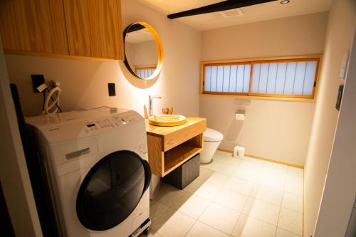 a bathroom with a washing machine and a sink at Auberge Homachi Mikuniminato in Sakai