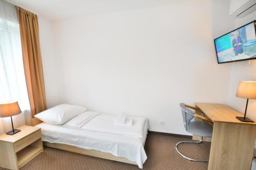 ein Hotelzimmer mit einem Bett und einem Schreibtisch in der Unterkunft Pokoje 4you Szczecin in Stettin