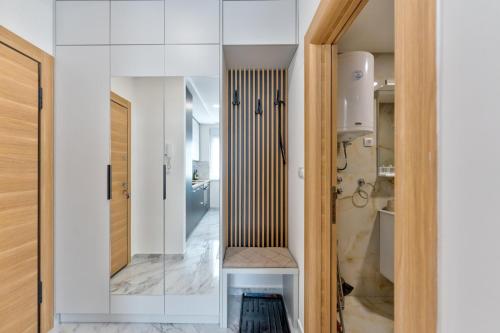 a bathroom with white walls and a glass door at Apartman Hanah Vip Bogic in Zlatibor