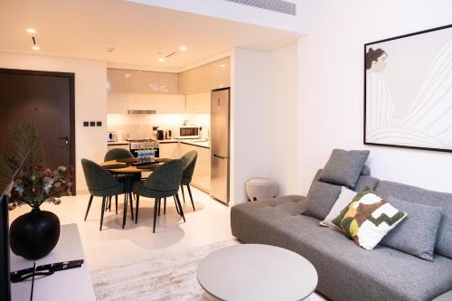 een woonkamer met een bank en een tafel bij Tranquil 1BR Haven in the Heart of Vista Bliss - P1AB01 in Dubai