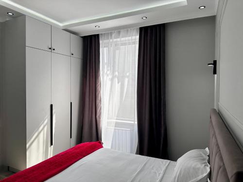 1 dormitorio con cama y ventana en apartments in Almaty, en Almaty