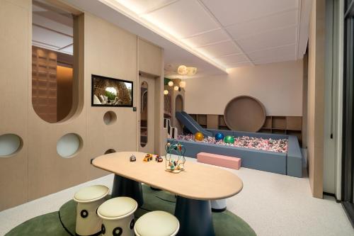 a childrens waiting room with a table and stools at Somerset Chayuan Chongqing in Chongqing