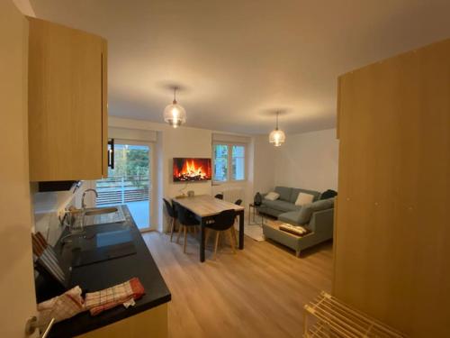 a kitchen and living room with a couch and a table at Appartement chaleureux au pied des pistes in Orbey