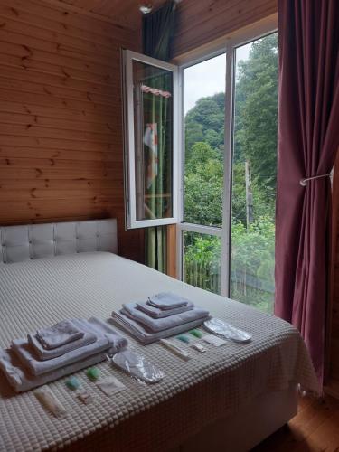 a bed with towels on it in front of a window at Saminavo in Chʼokhatauri