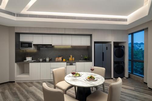 a kitchen and dining room with a table and chairs at Somerset Chayuan Chongqing in Chongqing